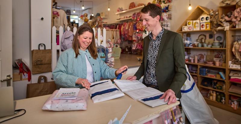 Brigitte en Marcel staan met de verpakkingen in de winkel van Brigitte