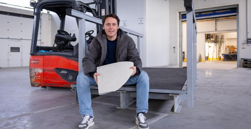 Circulair ondernemer Jochem Cuppen zit in een bedrijfshal met een stuk biocomposiet in zijn handen