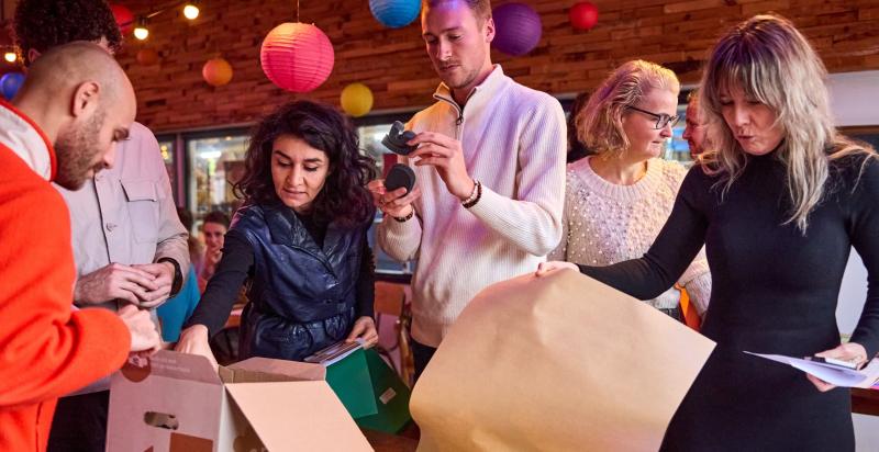 Groepje mensen staat rond een tafel voor een workshop