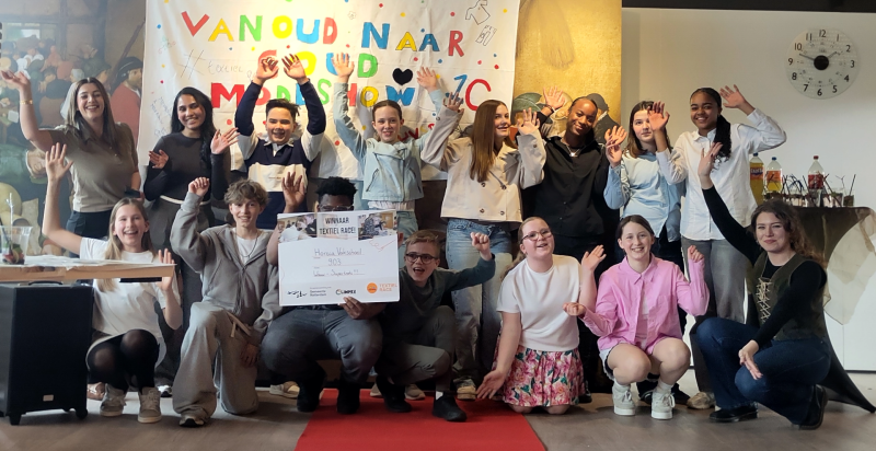 De foto laat juichende leerlingen zien met in hun hand de prijs voor de Textiel Race