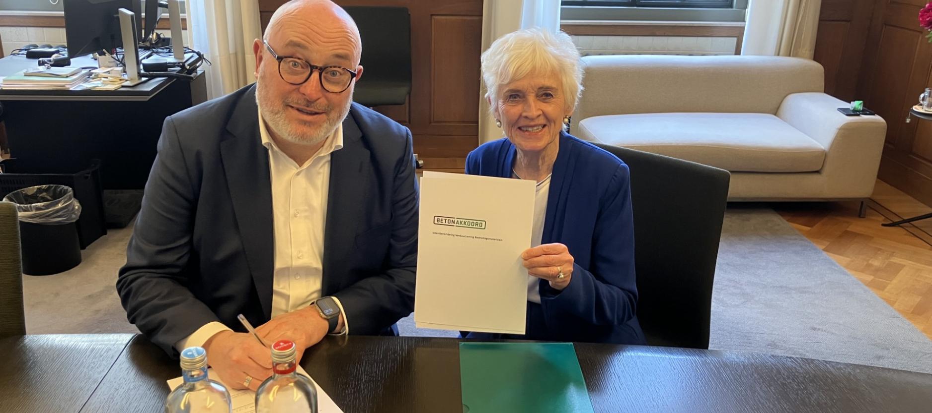 Wethouder Lansink-Bastemeijer en Jacqueline Cramer, voorzitter van het betonakkoord, ondertekenen een overeenkomst.