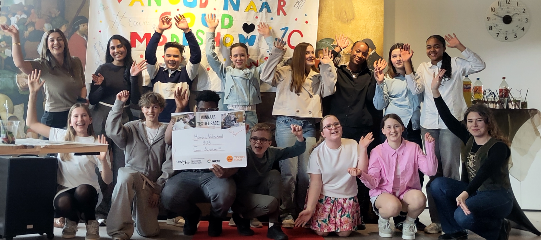 De foto laat juichende leerlingen zien met in hun hand de prijs voor de Textiel Race