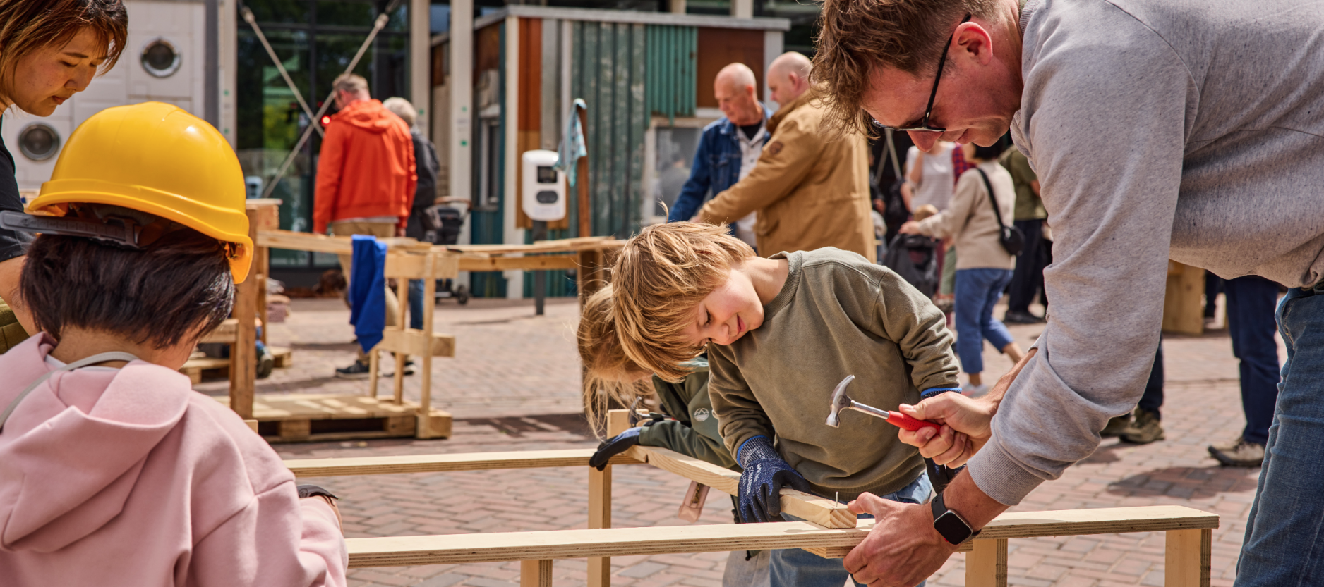 man en twee kinderen slaan met een hamer
