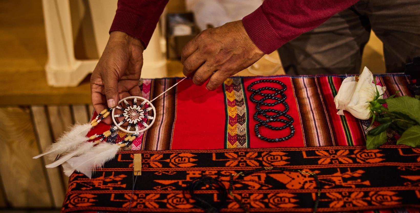 Vrouw legt een aantal spulletjes klaar op een tafel voor de tentoonstelling AYNI in circulair centrum De HER.